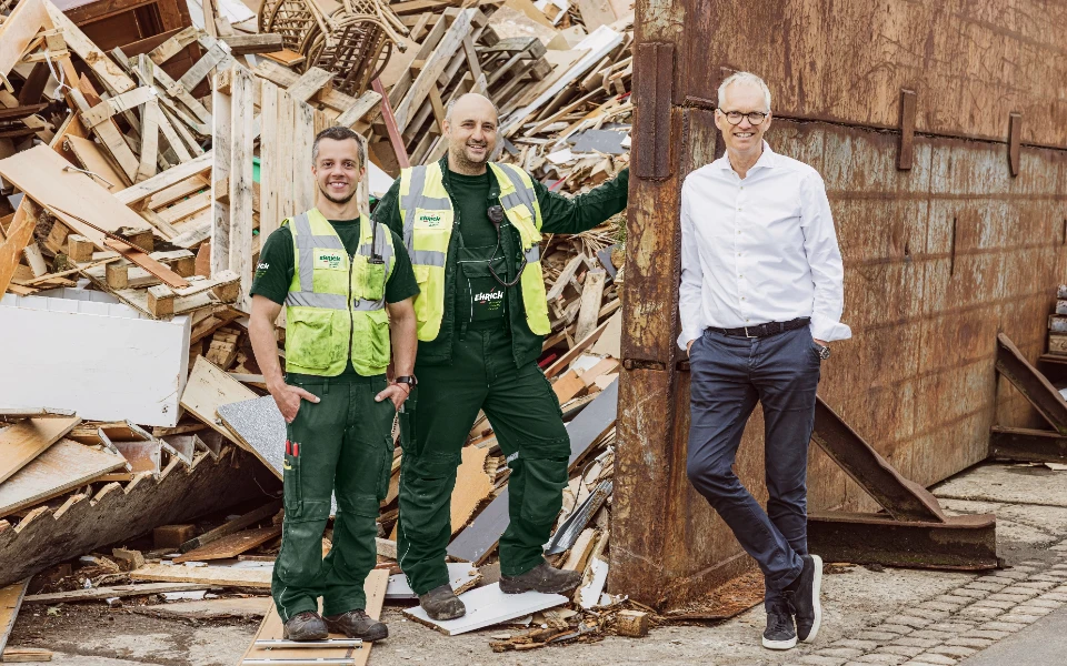 Der Chef von Ehrich steht mit zwei Angestellten auf dem Platz