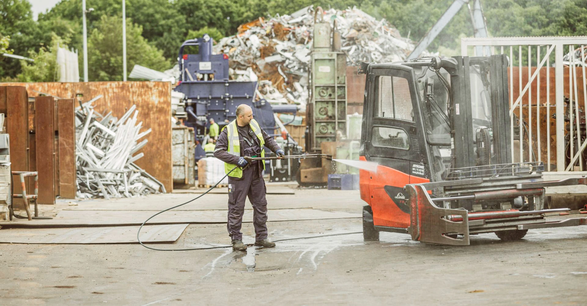 Ein Mitarbeiter reinigt einen Gabelstapler